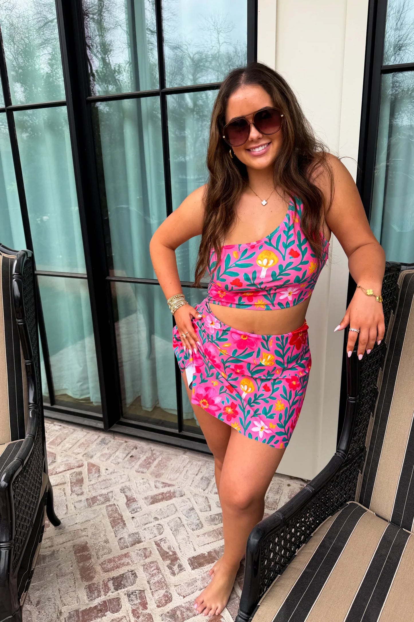 Woman wearing a colorful two-piece swimsuit on a patio.