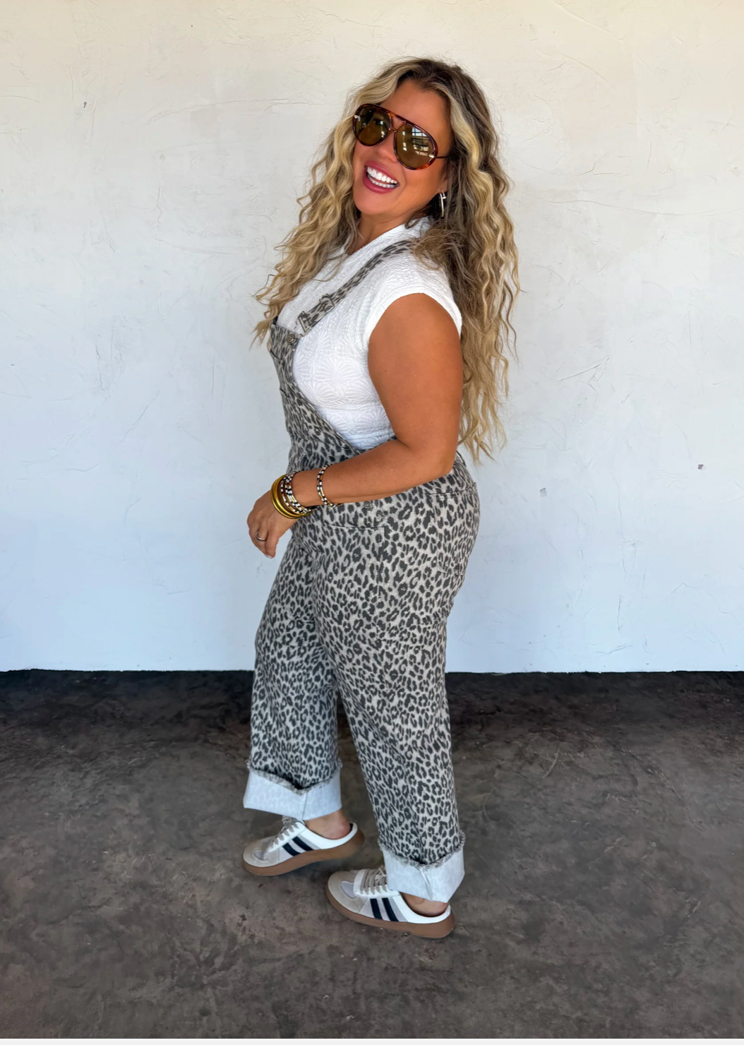 Woman wearing a leopard print outfit against a white wall
