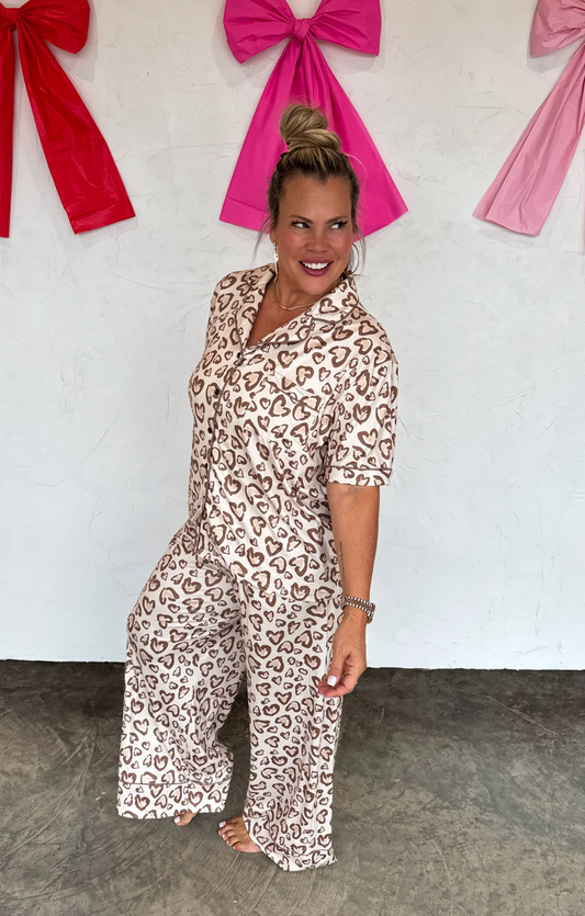 Woman wearing a leopard print outfit with pink and red bows in the background.