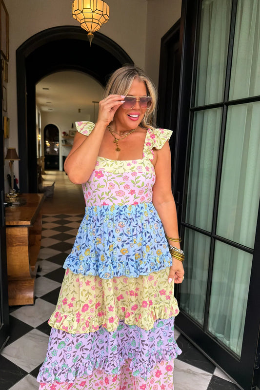 Woman wearing a colorful floral dress in an indoor setting.