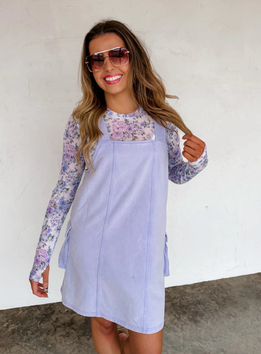 Woman wearing a light blue dress with floral patterns indoors.
