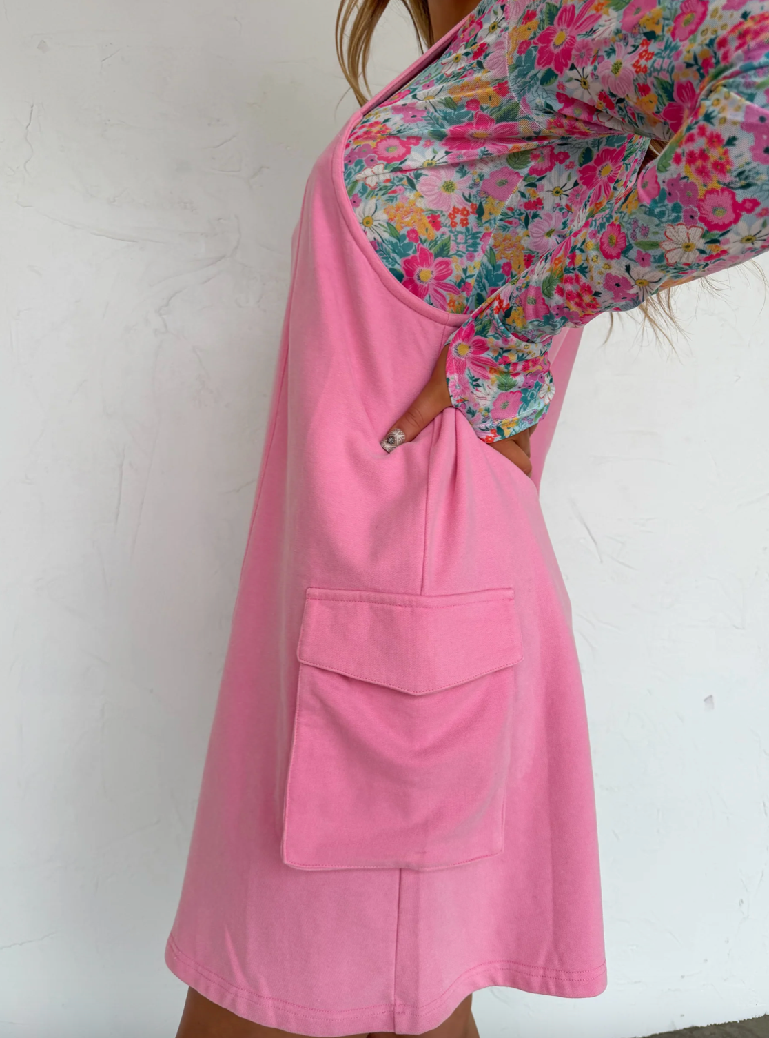 Pink apron with floral patterned pocket on a white background